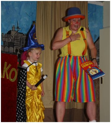 Clown Kiko krijgt hulp van een van de kinderen bij de truc met het kleurboekurboek