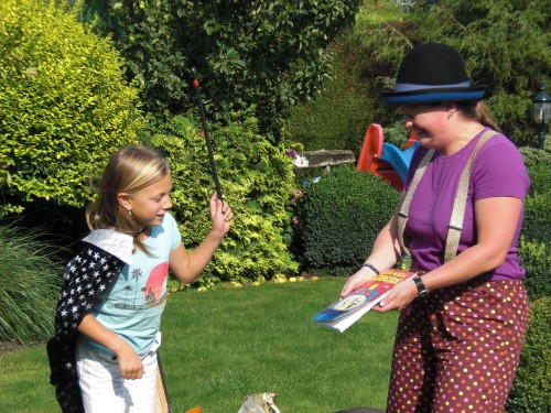 Clown Kiko krijgt hulp van een van de kinderen bij het goochelen tijdens de familieshow van Clown Kiko