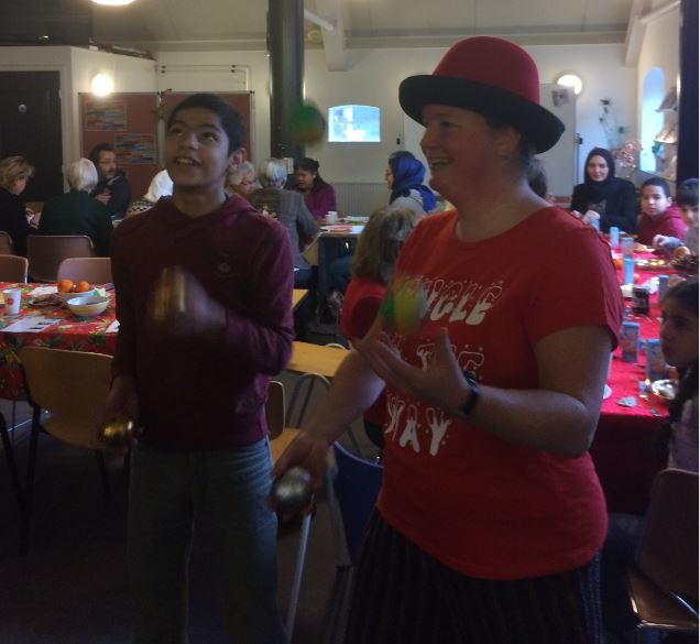 Jongleur Kiko tafeljongleren tijdens de kerst viering in het taalhuis in de bibliotheek van Leusden