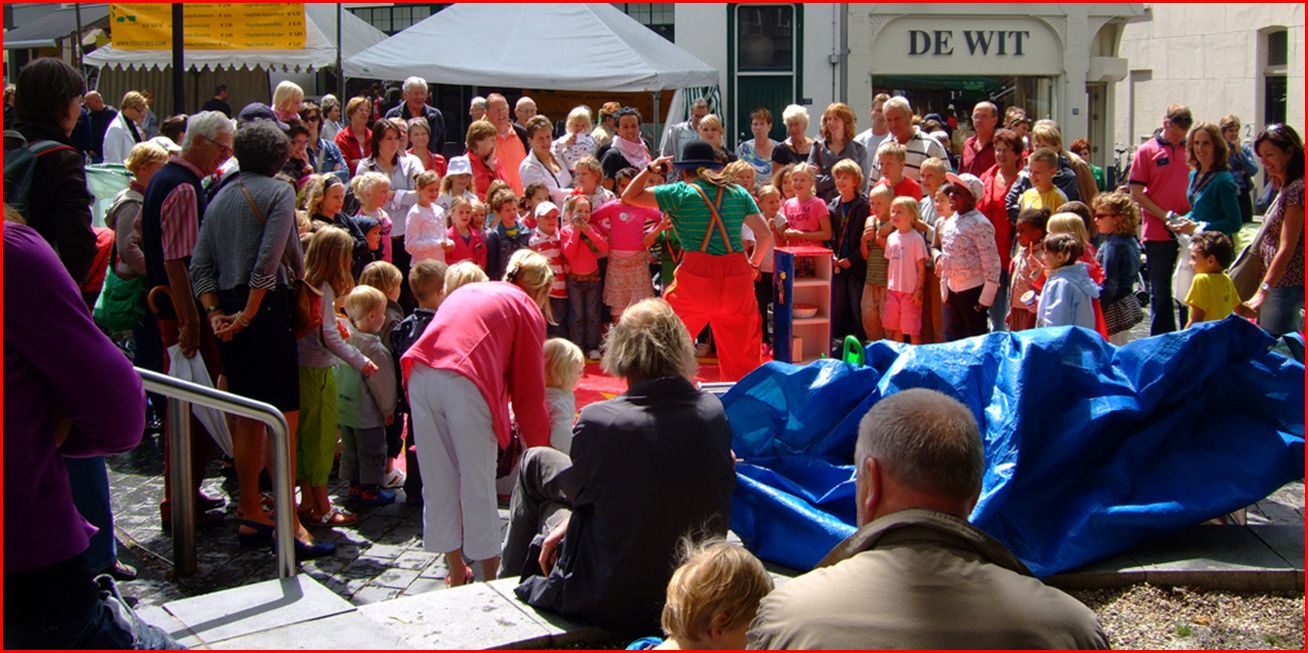 Straattheater kindershow van straatartiest Clown & Jongleur Kiko vierdaagsefeesten Nijmegen - spelen tussen de buien door, de grond is nog nat vandaar dat het publiek liever blijft staan :)